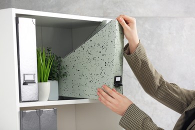 Photo of Woman taking folder from shelf in office, closeup