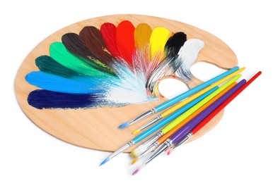 Photo of Palette with paints and brushes on white background. Artist equipment