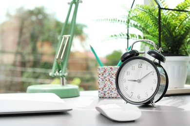 Alarm clock on table in office. Time to work