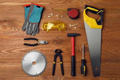 Photo of Different carpenter's tools on wooden background, flat lay