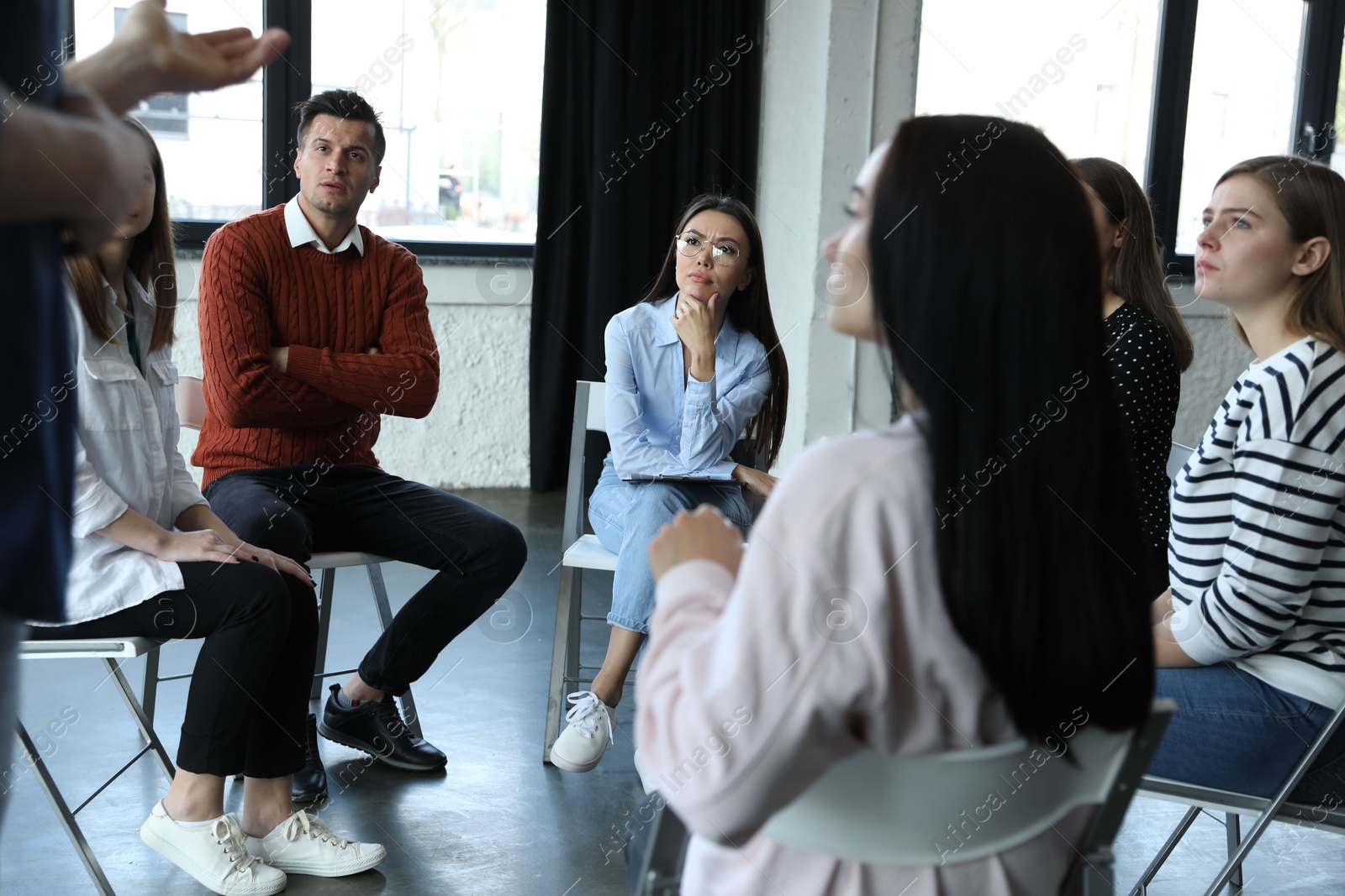 Photo of Psychotherapist working with patients in group therapy session indoors