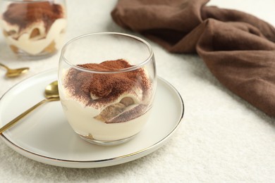 Photo of Delicious tiramisu in glass on white table, space for text