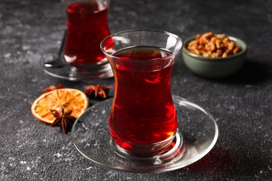 Photo of Glasses of traditional Turkish tea on grey textured table, closeup
