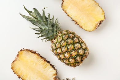 Photo of Fresh pineapples on light background, flat lay