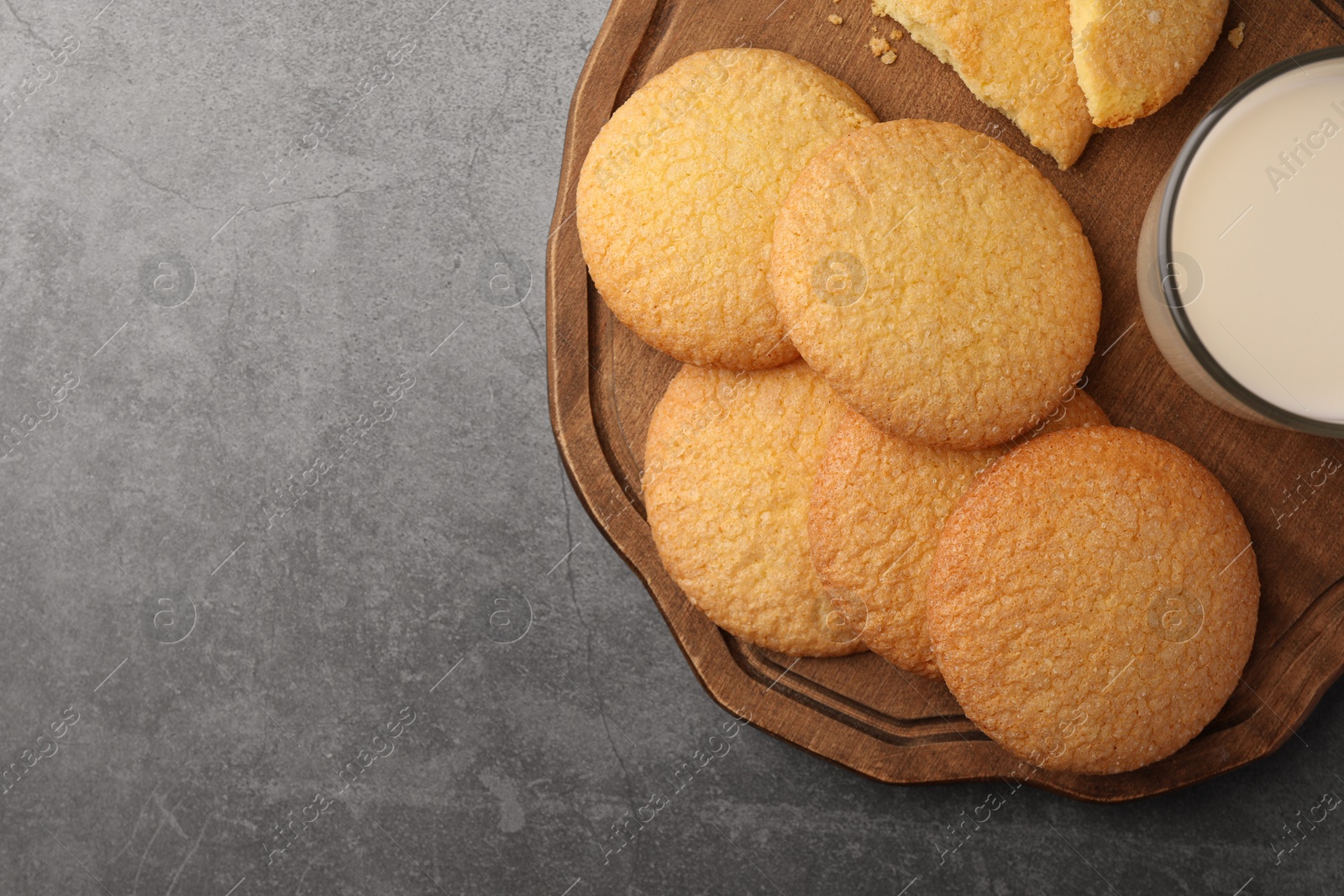 Photo of Delicious Danish butter cookies and milk on grey table, top view. Space for text