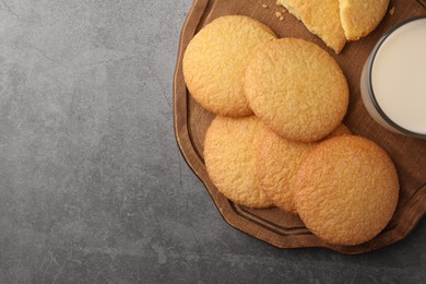 Photo of Delicious Danish butter cookies and milk on grey table, top view. Space for text