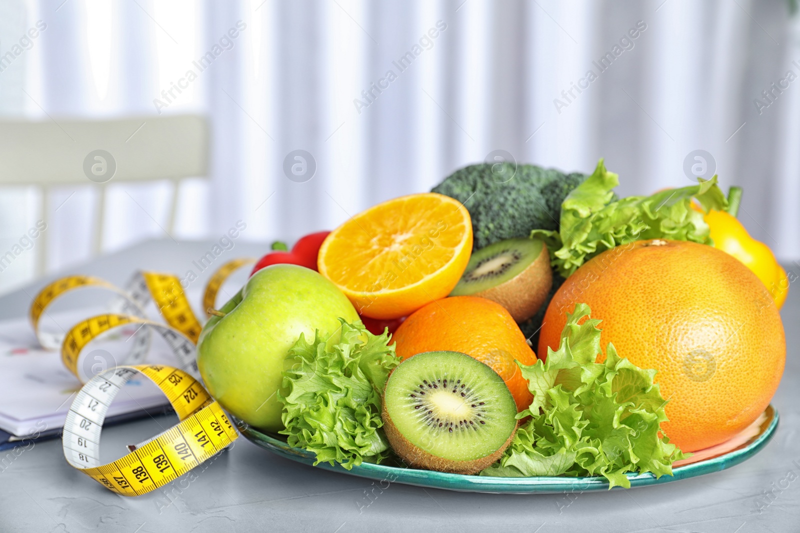 Photo of Measuring tape, vegetables and fruits on table. Diet plan from nutritionist