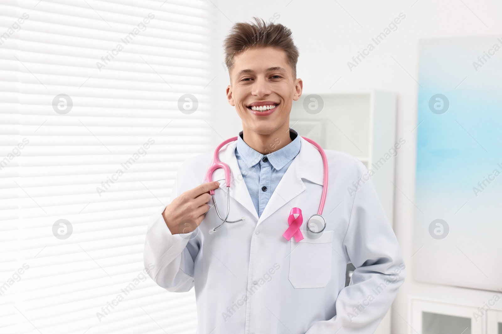 Photo of Mammologist with pink ribbon in hospital. Breast cancer awareness