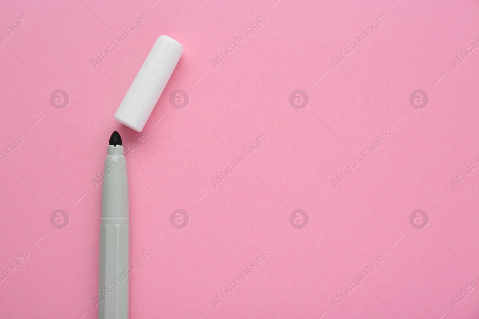 Photo of Bright grey marker and cap on light pink background, flat lay. Space for text