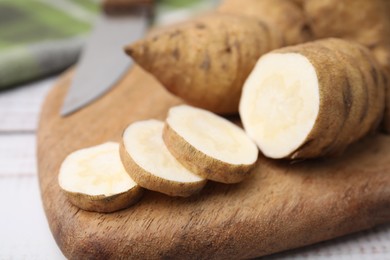 Photo of Whole and cut turnip rooted chervil tubers on table, closeup