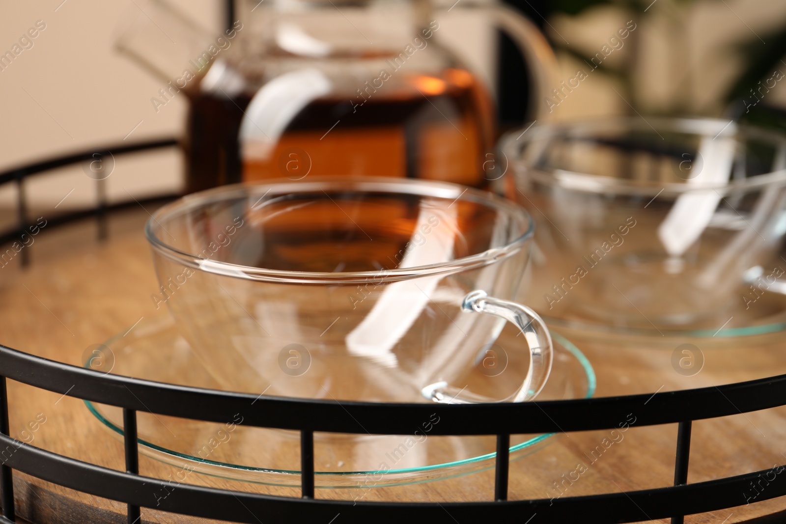 Photo of Clean glass cups and teapot on tray, closeup