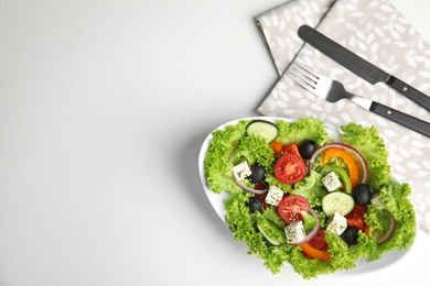 Photo of Tasty fresh Greek salad on white table, flat lay. Space for text