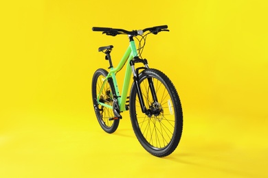 Photo of Modern bicycle on yellow background. Healthy lifestyle