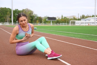 Young woman having heart attack while running at stadium