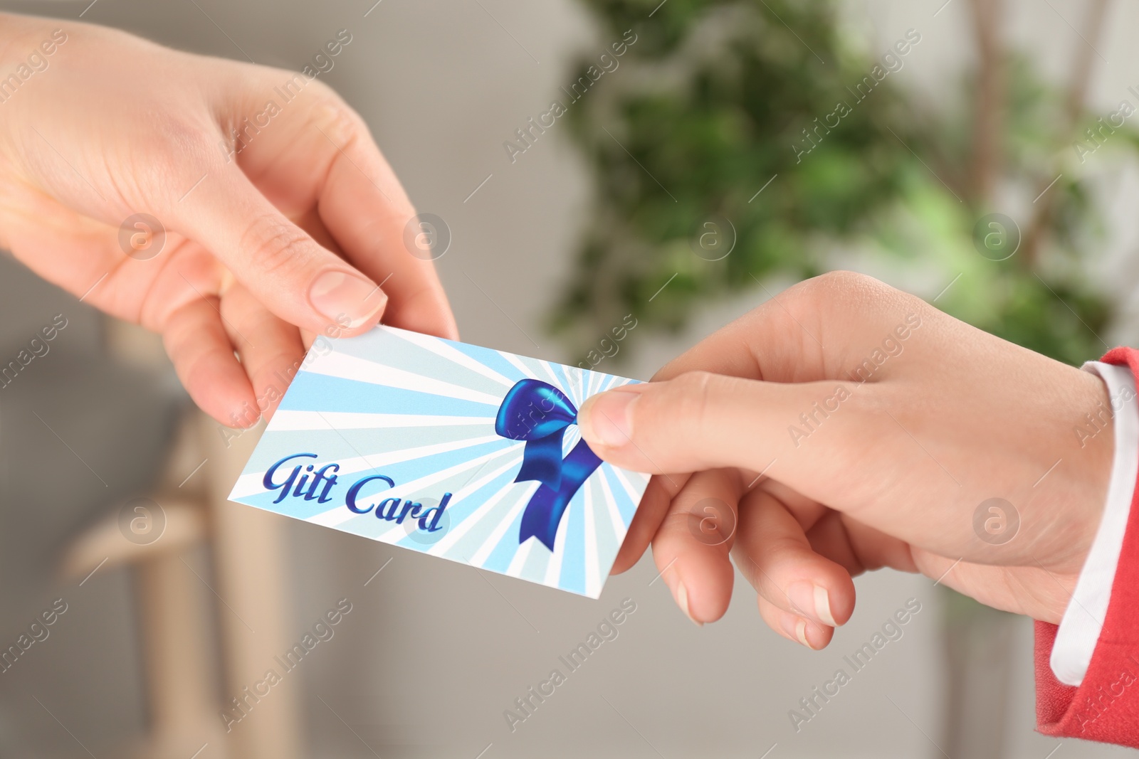 Photo of Women with gift card on blurred background, closeup 