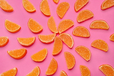 Delicious orange marmalade candies on pink background, flat lay