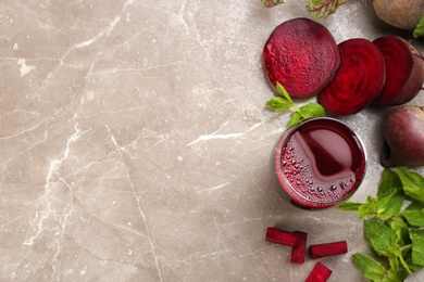 Photo of Freshly made beet juice on grey table, flat lay. Space for text