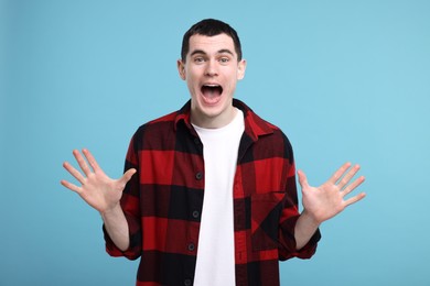 Photo of Portrait of surprised man on light blue background