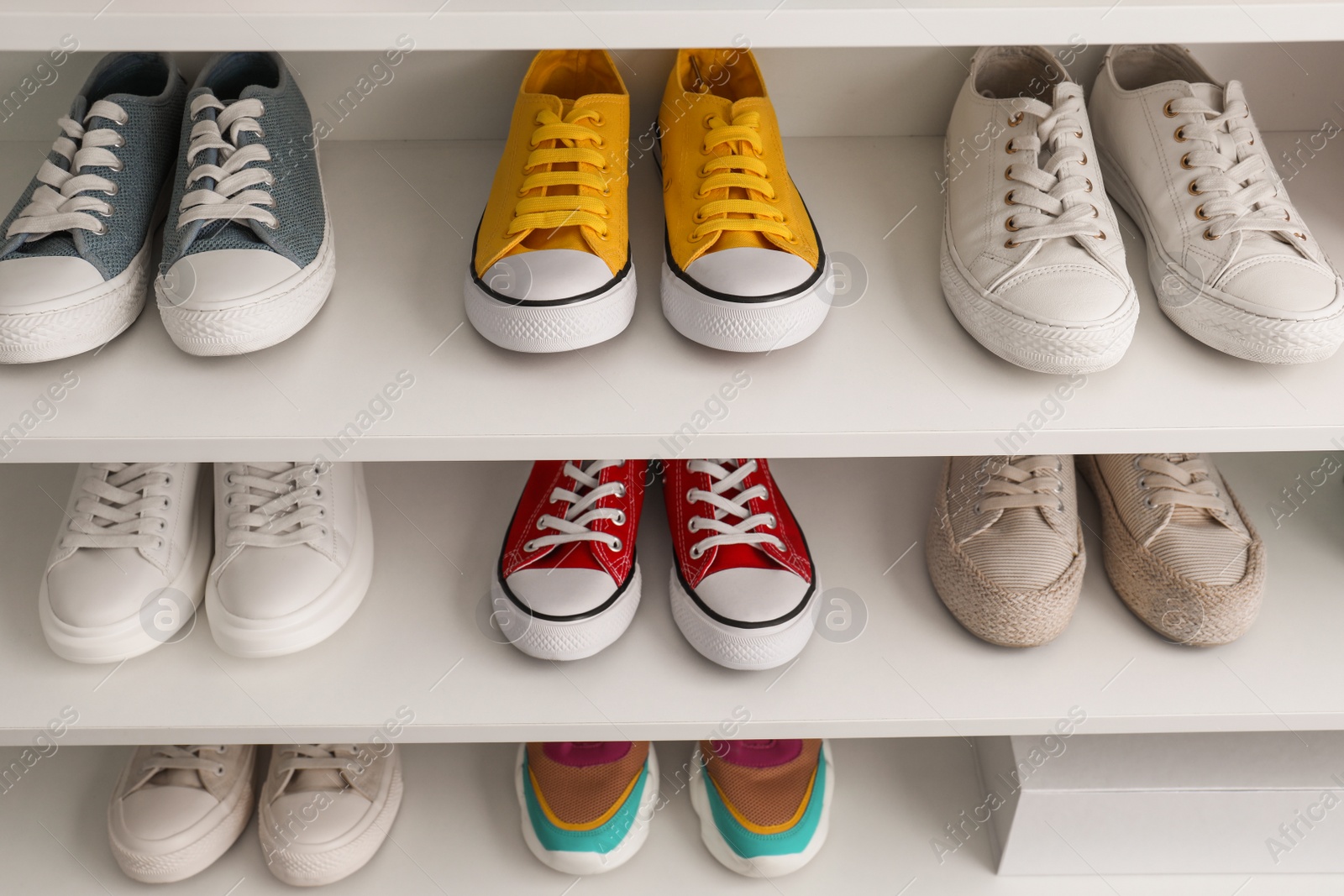 Photo of White shelving unit with collection of colorful sneakers