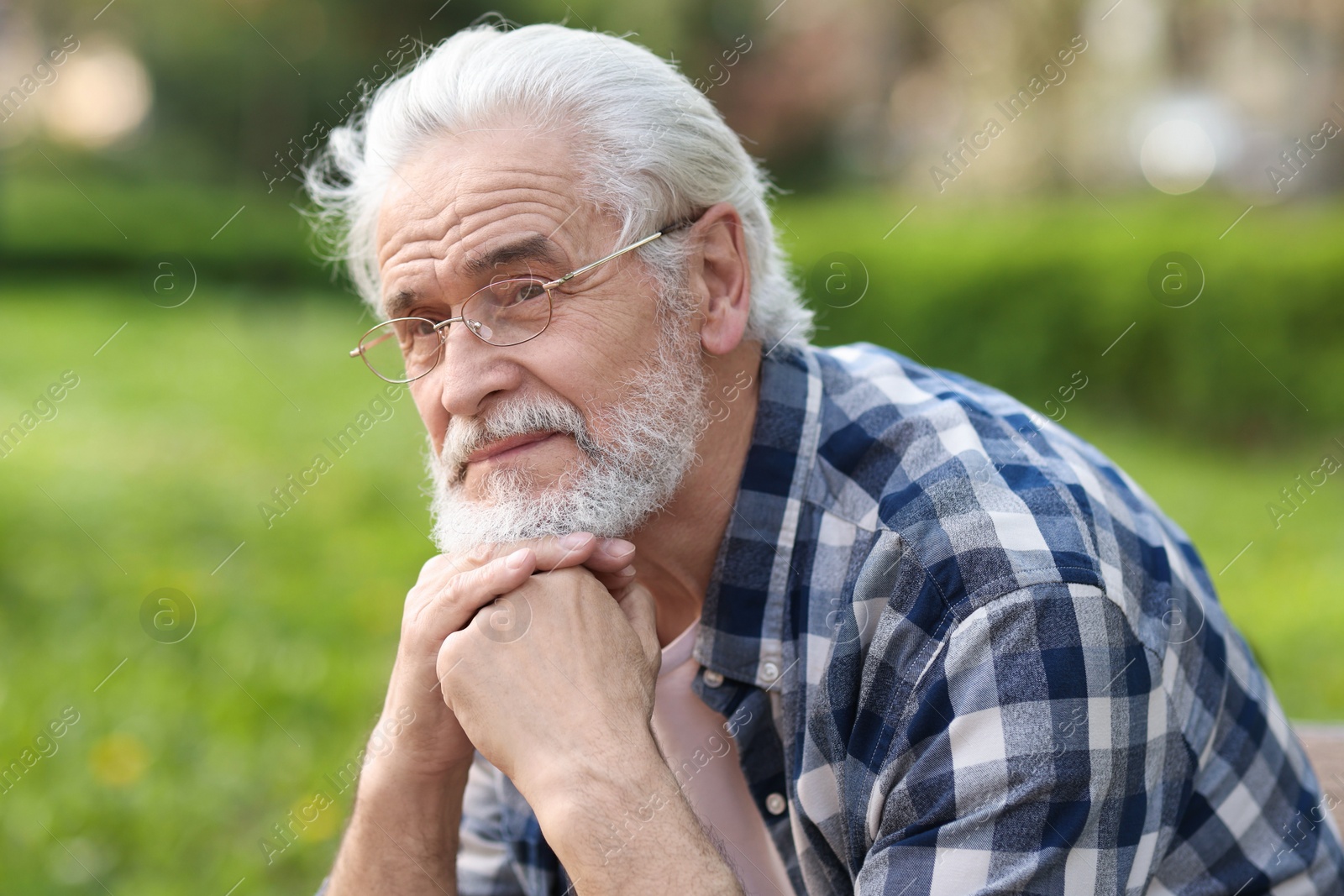 Photo of Portrait of happy grandpa with glasses in park