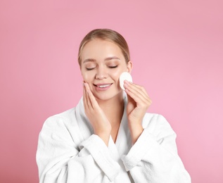 Photo of Beautiful young woman with cotton pad on pink background