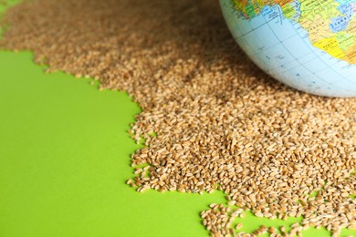 Photo of Globe and grains on light green background. Space for text. Hunger crisis concept