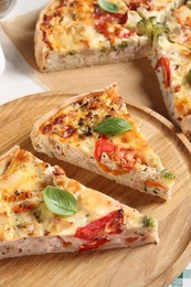 Tasty quiche with chicken, vegetables, basil and cheese on white table, closeup