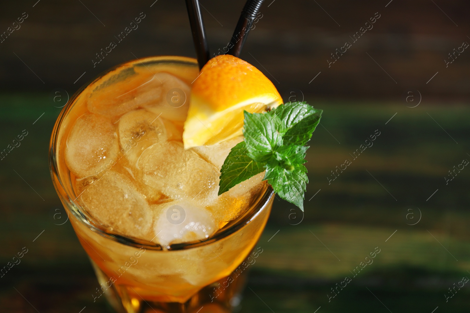 Photo of Glass of delicious cocktail with ice on table, closeup