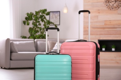 Photo of Colorful suitcases packed for journey in living room