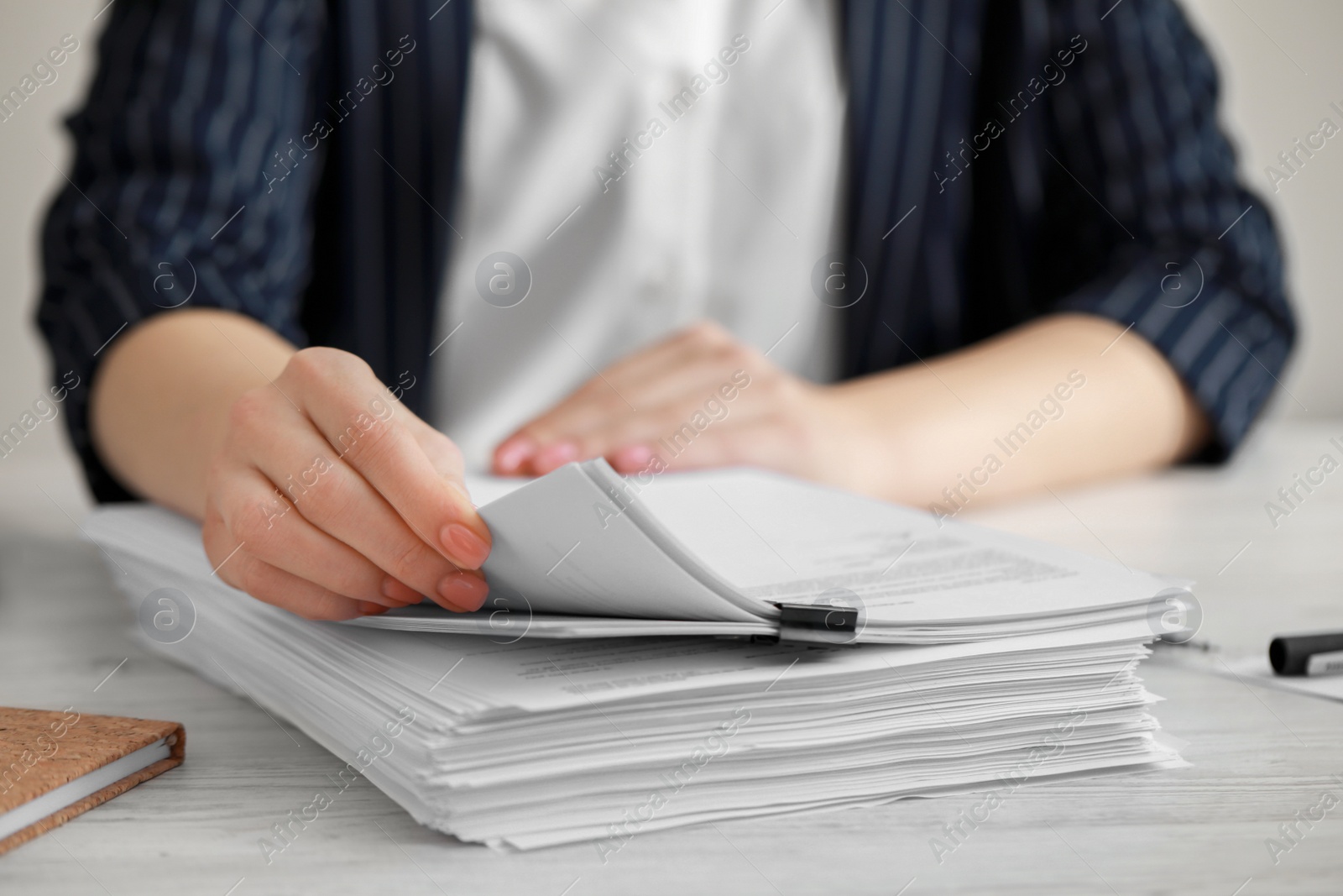 Photo of Woman reading documents at white wooden table in office, closeup. Space for text