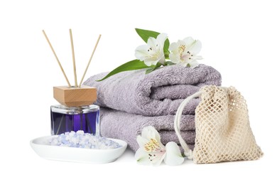 Photo of Spa composition. Towels, aromatherapy products, sea salt and beautiful flowers on white background
