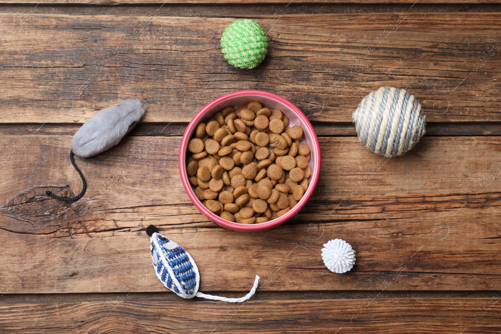 Photo of Flat lay composition with different pet toys and feeding bowl on wooden background