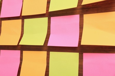 Photo of Many colorful stickers on wooden background, closeup