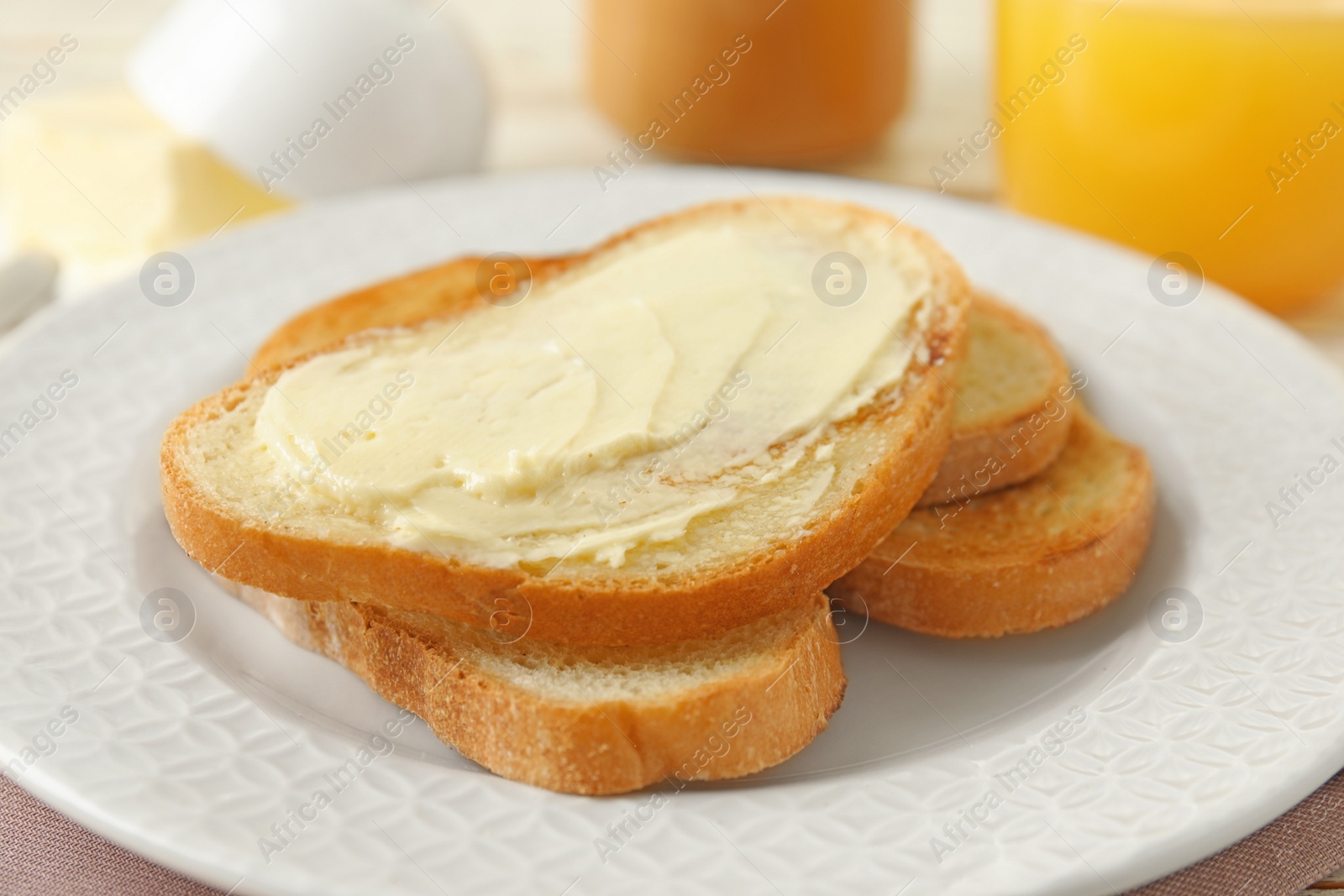 Photo of Tasty bread with butter on white plate, closeup