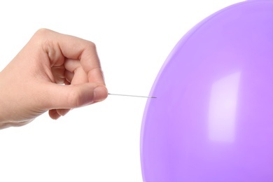 Woman piercing purple balloon on white background, closeup