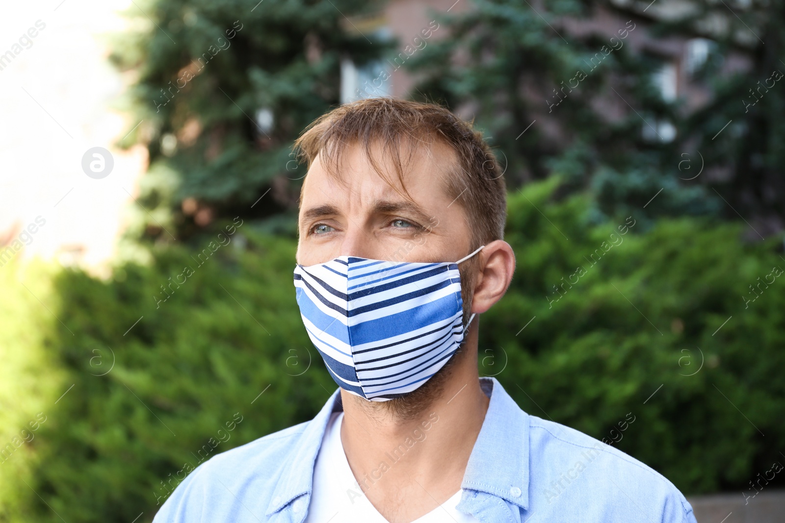 Photo of Man wearing handmade cloth mask outdoors. Personal protective equipment during COVID-19 pandemic