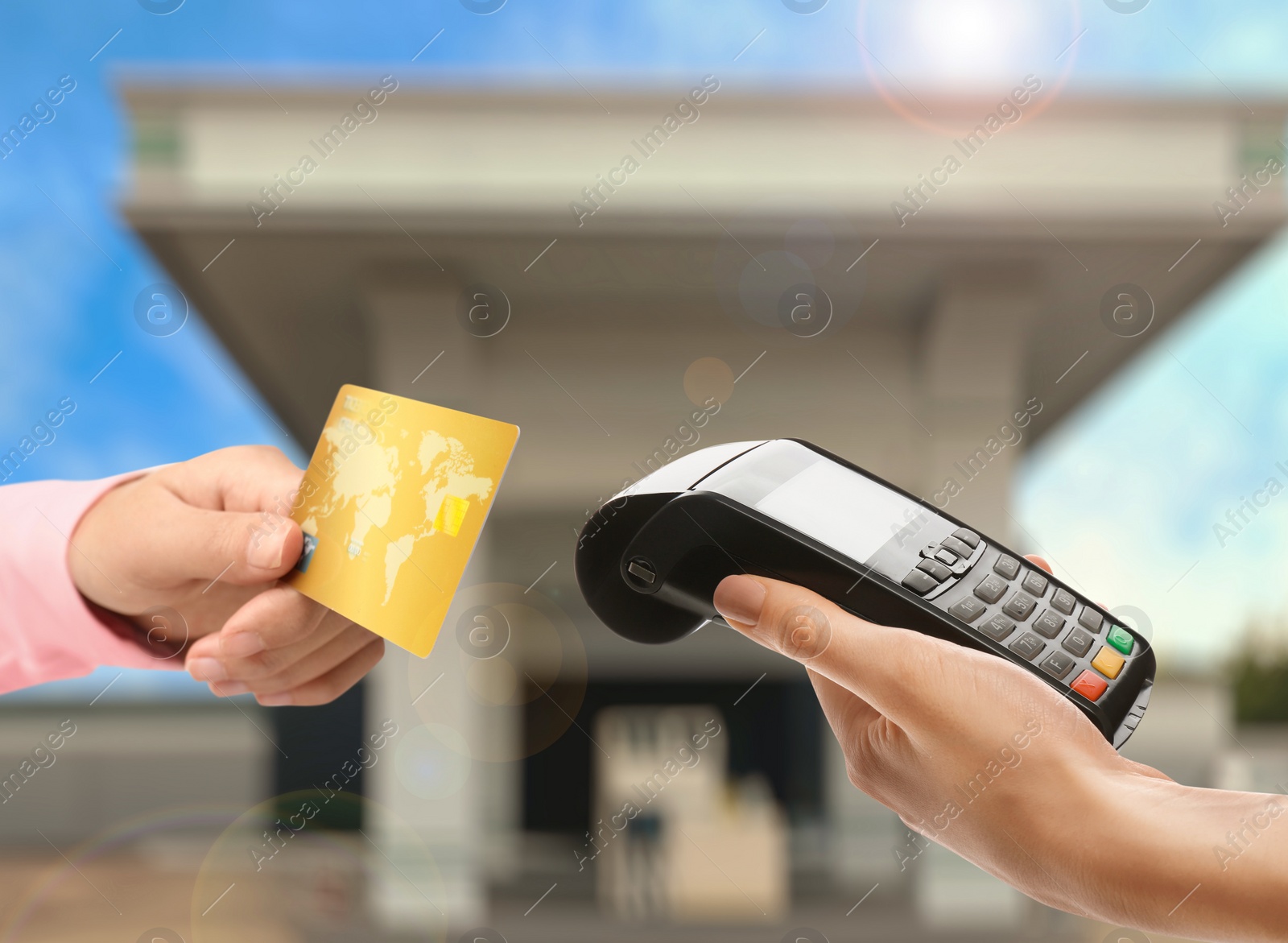 Image of Woman paying for fuel using credit card via payment terminal at gas station, closeup