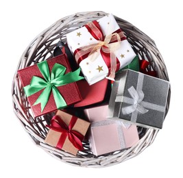 Photo of Wicker basket full of gift boxes on white background, top view