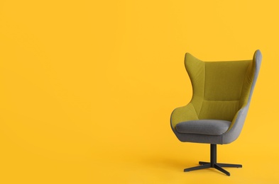 Photo of Modern office chair on yellow background. Space for text