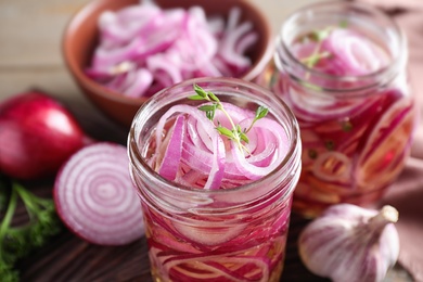 Photo of Jars of pickled onions on table, closeup
