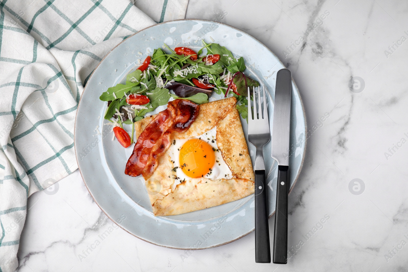 Photo of Delicious crepe with egg served on white marble table, flat lay. Breton galette
