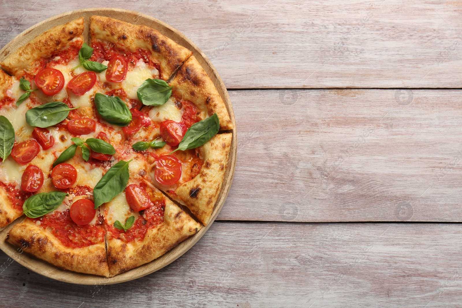 Photo of Delicious Margherita pizza on wooden table, top view. Space for text