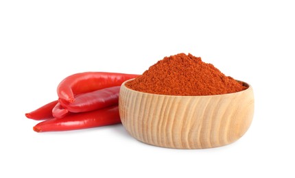 Fresh chili peppers and bowl of paprika powder on white background