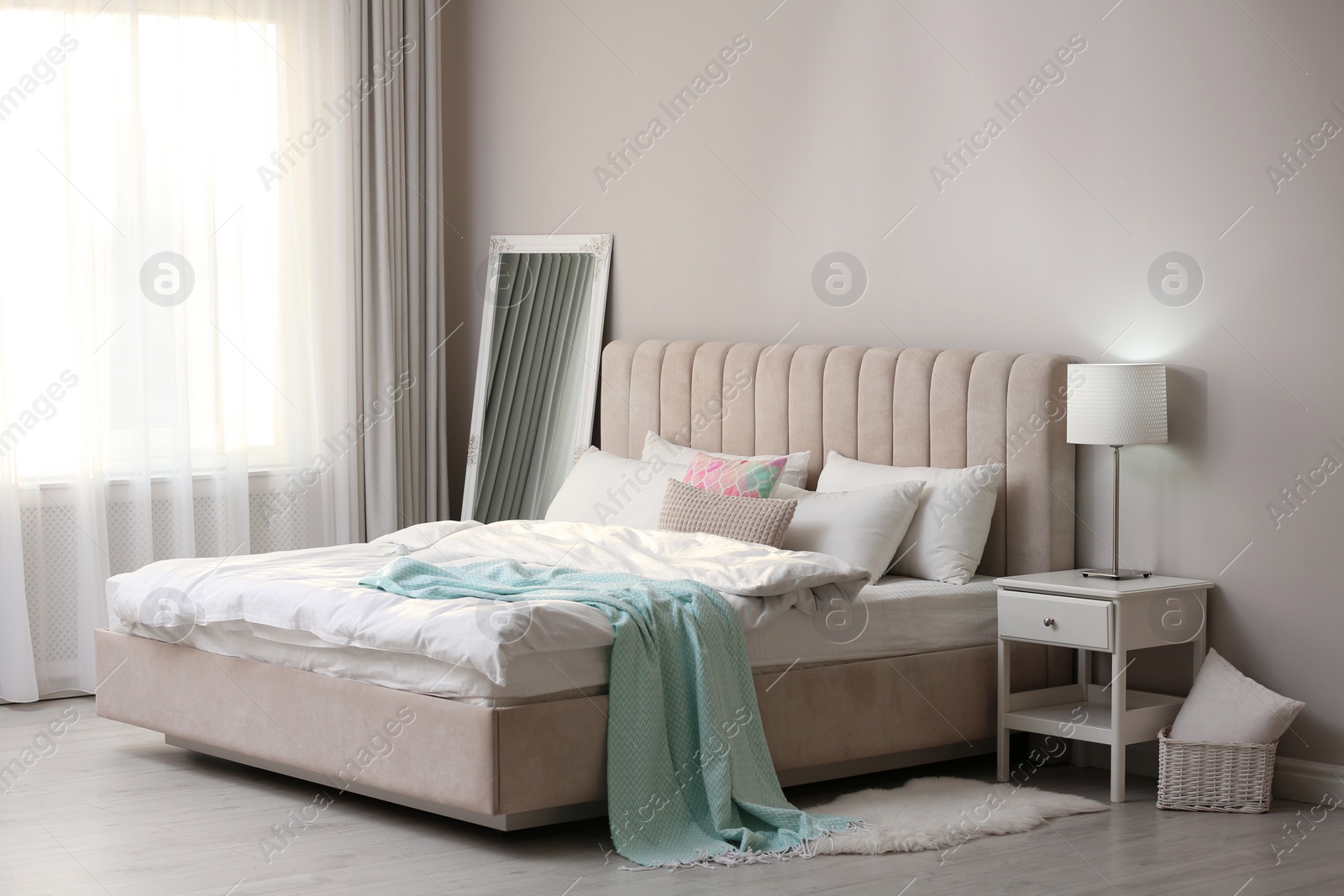 Photo of Stylish room interior with large comfortable bed 