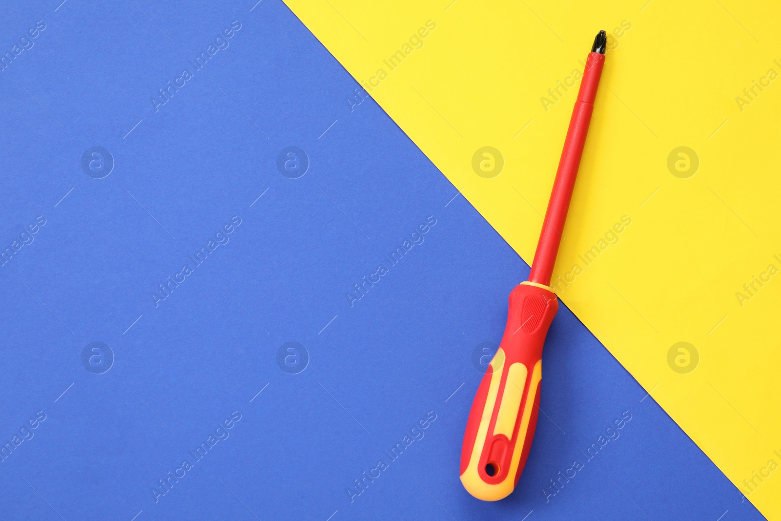 Photo of Screwdriver with red handle on color background, top view. Space for text