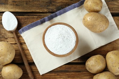 Photo of Starch and fresh potatoes on wooden table, flat lay