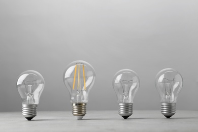 Photo of Vintage and modern lamp bulbs on grey background