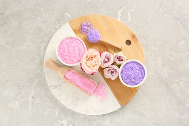 Photo of Sea salt and beautiful roses on light grey marble table, top view