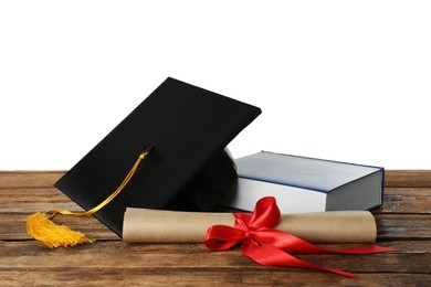 Graduation hat, book and diploma on wooden table against white background