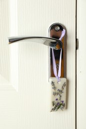 Photo of Scented sachet with flowers hanging on door handle